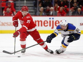 Detroit Red Wings center Dylan Larkin (71) and St. Louis Blues right wing Vladimir Tarasenko (91) battle for the puck in the first period of an NHL hockey game, Saturday, Dec. 9, 2017, in Detroit.