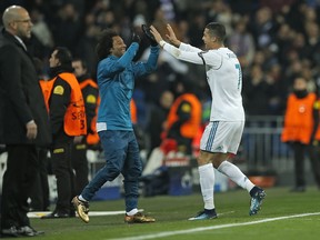 Real Madrid's Cristiano Ronaldo, right, celebrates with Real Madrid's Marcelo after he scored his side's second goal during the Champions League Group H soccer match between Real Madrid and Borussia Dortmund at the Santiago Bernabeu stadium in Madrid, Spain, Wednesday, Dec. 6, 2017. Dortmund coach Peter Boss on the left.