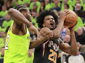 Phoenix Suns forward Josh Jackson (20) drives against Minnesota Timberwolves forward Andrew Wiggins (22) in the first quarter of an NBA basketball game on Saturday, Dec. 16, 2017, in Minneapolis.
