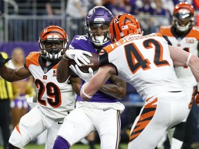 Minnesota Vikings wide receiver Stefon Diggs, center, catches a 20-yard touchdown pass between Cincinnati Bengals defenders Tony McRae, left, and Clayton Fejedelem, right, during the first half of an NFL football game, Sunday, Dec. 17, 2017, in Minneapolis.