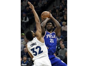 Minnesota Timberwolves center Karl-Anthony Towns (32) guards Philadelphia 76ers center Joel Embiid (21), of Cameroon, during the first quarter of an NBA basketball game on Tuesday, Dec. 12, 2017, in Minneapolis. Towns was called for a foul on the play.