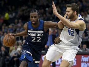 Minnesota Timberwolves forward Andrew Wiggins (22) drives against Dallas Mavericks forward Maximilian Kleber (42), of Germany, during the first quarter of an NBA basketball game on Sunday, Dec. 10, 2017, in Minneapolis. Wiggins was called for an offensive foul.