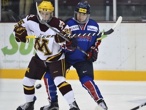 In this photo taken Sept. 24, 2017, South Korea's Marissa Brandt, right, defends against Minnesota forward Nicole Schammel in the first period of an exhibition hockey game in Minneapolis. Marissa, a native Korean who was adopted as an infant by parents in Minnesota, and her sister Hannah will both be playing in the upcoming Winter Olympics in women's hockey. Marissa for South Korea and Hannah for the U.S.
