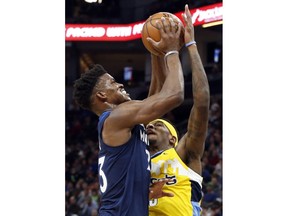 Minnesota Timberwolves' Jimmy Butler, left, attempts a shot as Denver Nuggets' Torrey Craig reaches up to block the ball in the first half of an NBA basketball game, Wednesday, Dec. 27, 2017, in Minneapolis.