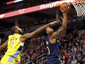 Minnesota Timberwolves' Jeff Teague, right, lays up as Denver Nuggets' Will Barton defends in the first half of an NBA basketball game Wednesday, Dec. 27, 2017, in Minneapolis.