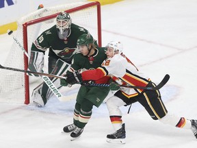 Minnesota Wild's Mikael Granlund (64) and Calgary Flames' Matt Stajan (18) watch the puck fly past the net in the first period of an NHL hockey game Tuesday, Dec. 12, 2017, in St. Paul, Minn.