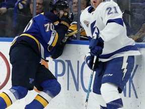 St. Louis Blues' Oskar Sundqvist, of Sweden, left, and Tampa Bay Lightning's Brayden Point, right, recoil after both players where hit with high sticks along the boards during the first period of an NHL hockey game Tuesday, Dec. 12, 2017, in St. Louis.