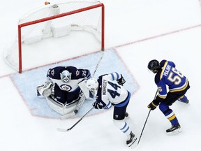 Winnipeg Jets goalie Steve Mason (35) blocks a puck as teammate Josh Morrissey and St. Louis Blues' Magnus Paajarvi (56), of Sweden, watch during the second period of an NHL hockey game Saturday, Dec. 16, 2017, in St. Louis.