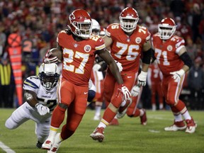Kansas City Chiefs running back Kareem Hunt (27) runs past a tackle attempt by Los Angeles Chargers linebacker Denzel Perryman (52) during the first half of an NFL football game in Kansas City, Mo., Saturday, Dec. 16, 2017.
