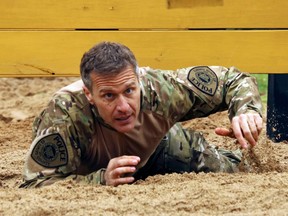 In this April 22, 2017, photo, Missouri Gov. Eric Greitens crawls under an obstacle during the SEMO SWAT Challenge in Fredericktown, Mo. Greitens is earning a reputation for public displays of physical prowess and revels in the attention, posting videos of his action adventures on Facebook and even using them to help stay fit while keeping a demanding schedule.