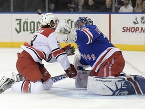 New York Rangers goalie Henrik Lundqvist (30) attempts to glove the puck as Carolina Hurricanes left wing Brock McGinn (23) closes in during the first period of an NHL hockey game Friday, Dec. 1, 2017, at Madison Square Garden in New York.