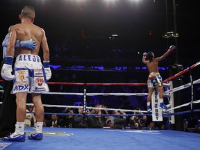 Juan Alejo, of Mexico, watches as Angel Acosta, of Puerto Rico, celebrates a 10th-round win during a WBO junior flyweight interim title boxing match Saturday, Dec. 2, 2017, in New York.