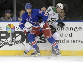 New York Rangers left wing Chris Kreider (20) battle for control of the puck with Dallas Stars' Jason Dickinson during the first period of an NHL hockey game Monday, Dec. 11, 2017, at Madison Square Garden in New York.