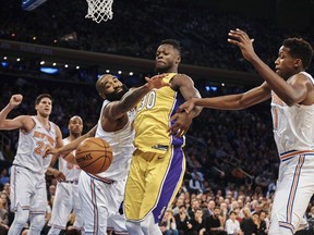 Los Angeles Lakers' Julius Randle, center right, competes for the ball with New York Knicks' Kyle O'Quinn, center left, during the first half of an NBA basketball game at Madison Square Garden in New York, Tuesday, Dec. 12, 2017.