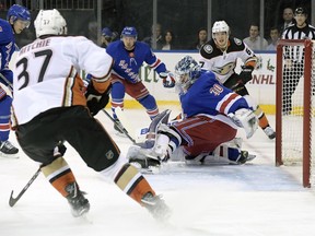 New York Rangers goalie Henrik Lundqvist (30) deflects the puck as Anaheim Ducks left wing Nick Ritchie (37) and center Rickard Rakell (67) close in during the first period of an NHL hockey game Tuesday, Dec. 19, 2017, at Madison Square Garden in New York.