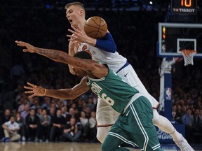 New York Knicks' Kristaps Porzingis, top, competes for the ball with Boston Celtics' Marcus Smart, bottom, during the first half of an NBA basketball game at Madison Square Garden in New York, Thursday, Dec. 21, 2017.