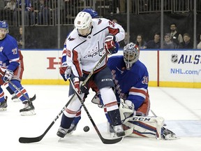 Washington Capitals right wing Alex Chiasson (39) battles for control of the puck with New York Rangers right wing Mats Zuccarello, rear, as New York Rangers goalie Ondrej Pavelec (31) guards the net during the first period of an NHL hockey game, Wednesday, Dec. 27, 2017, at Madison Square Garden in New York.