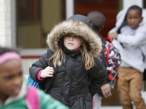 North Bay Elementary School student Vivian Moore, 7, of Biloxi, Miss., braces against the cold weather as she walks to her bus after school on Wednesday, Dec., 6, 2017. Forecasters say conditions could be right for snowfall in South Mississippi late Thursday or early Friday.