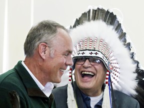 In this March 10, 2017 photo, Blackfeet Tribal Business Council Chairman Harry Barnes laughs with Interior Secretary Ryan Zinke after a ceremony with members of the Blackfeet tribe in West Glacier, Mont. Even as it clashes with American Indians over reductions to national monuments in the Southwest, the Trump administration is engaging with a Montana tribe over the creation of a new monument next to its reservation.