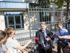 FILE - In this file photo taken on  July 19, 2017 shows Hungarian member of the European Parliament and member of the far-right Jobbik party Bela Kovacs, center, as he speaks to journalists before his interrogation in front of the Central Prosecutor's Office in Budapest, Hungary. Hungarian prosecutors say they have indicted Kovacs for allegedly spying on the European Union. The Chief Investigative Prosecutor's Office said Wednesday, Dec. 6, 2017 that charges against him also include fraud totaling 21,079 euro (US $24,900) stemming from the fictitious employment of interns in the EU parliament.