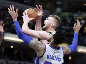 Indiana Pacers center Domantas Sabonis (11) is fouled as he shoots by Detroit Pistons forward Eric Moreland (24) during the second half of an NBA basketball game in Indianapolis, Friday, Dec. 15, 2017. The Pistons defeated the Pacers 104-98.