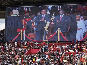 FILE - In this Tuesday, Nov. 28, 2017 file photo, the crowd watch as Kenyan President Uhuru Kenyatta, center, and Deputy President William Ruto, center right, appear on a video screen at his inauguration ceremony at Kasarani stadium in Nairobi, Kenya. Citing the need to be "more integrated," Kenyan President Uhuru Kenyatta announced during his inauguration that the East African commercial hub will now give visas on arrival to all Africans.