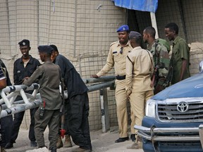 Somali police guard the road leading to the scene of a suicide bomb attack on a police academy in the capital Mogadishu, Somalia Thursday, Dec. 14, 2017. An Islamic extremist suicide bomber disguised as a police officer killed at least 10 people at a police academy in Somalia's capital on Thursday, police said.