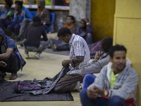 In this photo taken Friday, Dec. 22, 2017, an Ethiopian migrant holds his clothes after being deported from Saudi Arabia, at the airport in Addis Ababa, Ethiopia. Undocumented Ethiopian migrants who are being forcibly deported from Saudi Arabia by the thousands in a new crackdown say they were mistreated by authorities while detained.