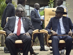 FILE - In this Friday, April 29, 2016 file photo, the then South Sudan's First Vice President Riek Machar, left, looks across at President Salva Kiir, right, as they sit to be photographed following the first meeting of a new transitional coalition government, in the capital Juba, South Sudan. South Sudan's warring factions on Thursday, Dec. 21, 2017 signed a new agreement to cease hostilities and protect civilians in the latest effort to calm a devastating civil war.