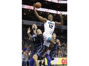Charlotte Hornets' Dwight Howard (12) drives against Orlando Magic's Nikola Vucevic (9) during the first half of an NBA basketball game in Charlotte, N.C., Monday, Dec. 4, 2017.