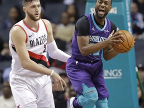Charlotte Hornets' Kemba Walker, right, reacts after being fouled by Portland Trail Blazers' Jusuf Nurkic, left, during the first half of an NBA basketball game in Charlotte, N.C., Saturday, Dec. 16, 2017.
