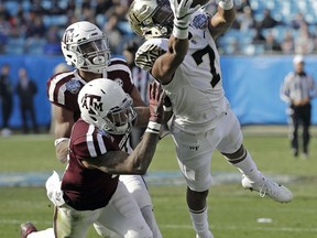 Wake Forest's Scotty Washington (7) catches a pass as Texas A&M's Larry Pryor (11) and Myles Jones (10) defend during the first half of the Belk Bowl NCAA college football game in Charlotte, N.C., Friday, Dec. 29, 2017.