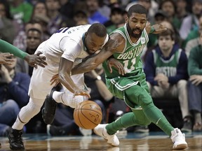 Charlotte Hornets' Kemba Walker, left, and Boston Celtics' Kyrie Irving, right, battle for the ball during the first half of an NBA basketball game in Charlotte, N.C., Wednesday, Dec. 27, 2017.