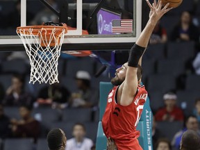 Toronto Raptors' Jonas Valanciunas (17) goes up to catch a pass as Charlotte Hornets' Dwight Howard (12) defends during the first half of an NBA basketball game in Charlotte, N.C., Wednesday, Dec. 20, 2017.