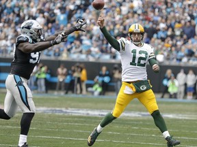 Green Bay Packers' Aaron Rodgers (12) throws a pass under pressure from Carolina Panthers' Mario Addison (97) during the first half of an NFL football game in Charlotte, N.C., Sunday, Dec. 17, 2017.