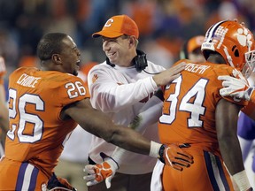 Clemson head coach Dabo Swinney, center, congratulates his players during the second half of the Atlantic Coast Conference championship NCAA college football game against Miami in Charlotte, N.C., Saturday, Dec. 2, 2017.