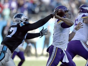 Minnesota Vikings' Case Keenum, right, tries to throw a pass as Carolina Panthers' Mario Addison, left, reaches in during the second half of an NFL football game in Charlotte, N.C., Sunday, Dec. 10, 2017.