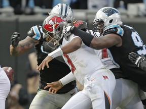 Tampa Bay Buccaneers' Jameis Winston (3) fumbles the ball as he his hit by Carolina Panthers' Mario Addison (97) during the second half of an NFL football game in Charlotte, N.C., Sunday, Dec. 24, 2017. The Panthers recovered the ball.