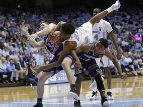 North Carolina's Sterling Manley (21) falls over Western Carolina's Onno Steger (33) and Desmond Johnson (1) during the first half of an NCAA college basketball game in Chapel Hill, N.C., Wednesday, Dec. 6, 2017.