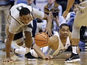 Wake Forest's Brandon Childress (0) grabs a loose ball while North Carolina's Garrison Brooks falls to the floor during the first half of an NCAA college basketball game in Chapel Hill, N.C., Saturday, Dec. 30, 2017.