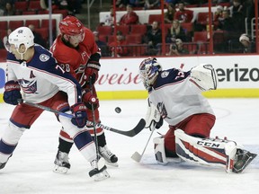 Carolina Hurricanes' Elias Lindholm (28), of Sweden, tries to shoot against Columbus Blue Jackets' Jack Johnson (7) and goalie Sergei Bobrovsky, of Russia, during the second period of an NHL hockey game in Raleigh, N.C., Saturday, Dec. 16, 2017.