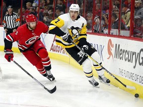 Pittsburgh Penguins' Evgeni Malkin (71) reaches for the puck as Carolina Hurricanes' Klas Dahlbeck (6) defends during the first period of an NHL hockey game, Friday, Dec. 29, 2017, in Raleigh, N.C.
