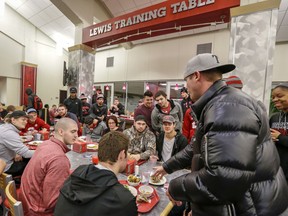 In this Jan. 19, 2017, photo, a magician performs card tricks at the Lewis Training Table facility at the University of Nebraska in Lincoln, Neb., where athletes can dine on specially made entrees such as mahi mahi steaks, bison meatloaf or chicken marsala. The hundreds of millions of dollars that have poured into the Power Five conferences, much of it from television rights fees, have enriched dozens of schools and allowed them to give their athletes the best of everything, right down to what they eat every day.