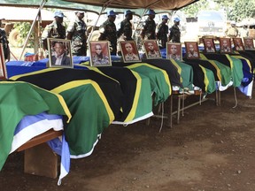 U.N peacekeepers stand behind coffins with the remains of Tanzanian peace keepers killed by rebels, during a memorial ceremony in Beni, eastern Congo, Monday, Dec. 11, 2017. The United Nations Deputy Special Representative for Congo says military offenses will be launched against rebels killed at least 15 Tanzanian U.N. peacekeepers last week in eastern Congo.