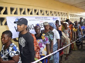 FILE - In this Oct. 10, 2017, file photo, people wait to cast their votes during a Presidential election in Monrovia, Liberia. Liberians head to the polls Tuesday Dec. 26, 2017 for a runoff election between a former international soccer star and the vice president to replace Africa's first female head of state.