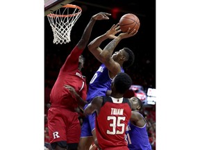 Seton Hall forward Desi Rodriguez, center, goes up for a shot against Rutgers forward Candido Sa, left, during the first half of an NCAA college basketball game, Saturday, Dec. 16, 2017, in Piscataway, N.J. Rutgers' Issa Thiam (35) and Seton Hall's Angel Delgado (31) look on during the play.