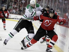 New Jersey Devils left wing Miles Wood (44) is checked by Dallas Stars defenseman Stephen Johns (28) during the second period of an NHL hockey game, Friday, Dec. 15, 2017, in Newark, N.J.
