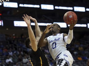 Seton Hall's Khadeen Carrington, right, takes a shot past Virginia Commonwealth's Sean Mobley, left,  during the first half of an NCAA college basketball game Saturday, Dec. 9, 2017, in Newark, N.J.