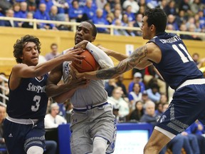 Seton Hall's Khadeen Carrington, center fights off St. Peter's Elijah Gonzales (3) and Nnamdi Enechionyia (11) as he charges the basket during the first half of an NCAA college basketball game in South Orange, N.J., Tuesday, Dec. 12, 2017.