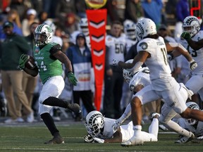 Marshall running back Keion Davis (24) avoids the tackle by Colorado State cornerback Anthony Hawkins (14) while rushing to the end zone to score a touchdown during the first half of the New Mexico Bowl NCAA college football game in Albuquerque, N.M., Saturday, Dec. 16, 2017.
